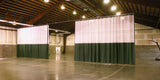 Two green and white divider curtains separating a gymnasium space.