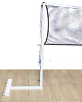 Portable white badminton net system with a black net and wheeled base on a wooden floor.