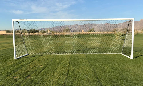 White aluminum soccer goal with a hexagonal net on a green field.