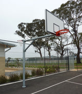 Galvanized steel pole with netball hoop & basketball backboard with orange rim & white net on an outdoor court.