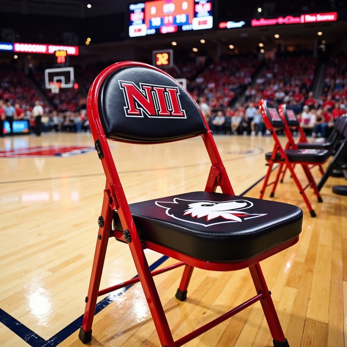 Red folding chair with black seat and back, custom branded with "NII" and a white wolf logo, on a basketball court.