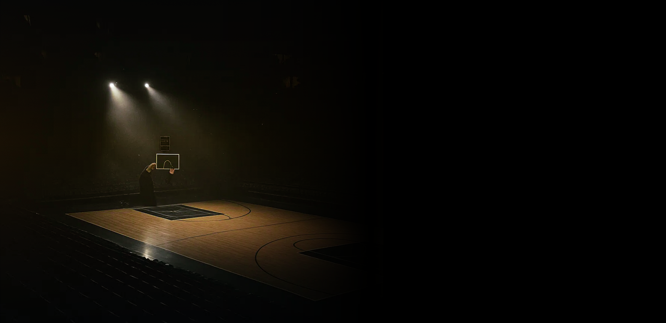 Your Championship Blueprint Starts Here | Custom Coaching Boards An atmospheric image of a person standing alone on a spotlighted basketball court in a dark arena. The text overlay reads,