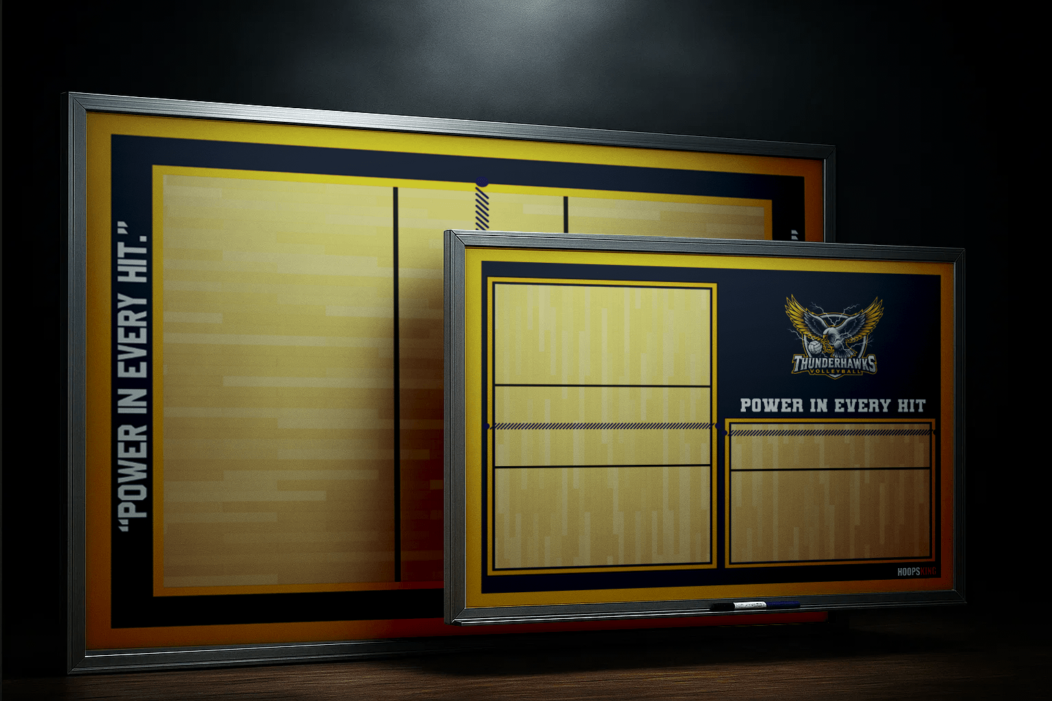 A smiling basketball coach points to a play on a large, wall-mounted