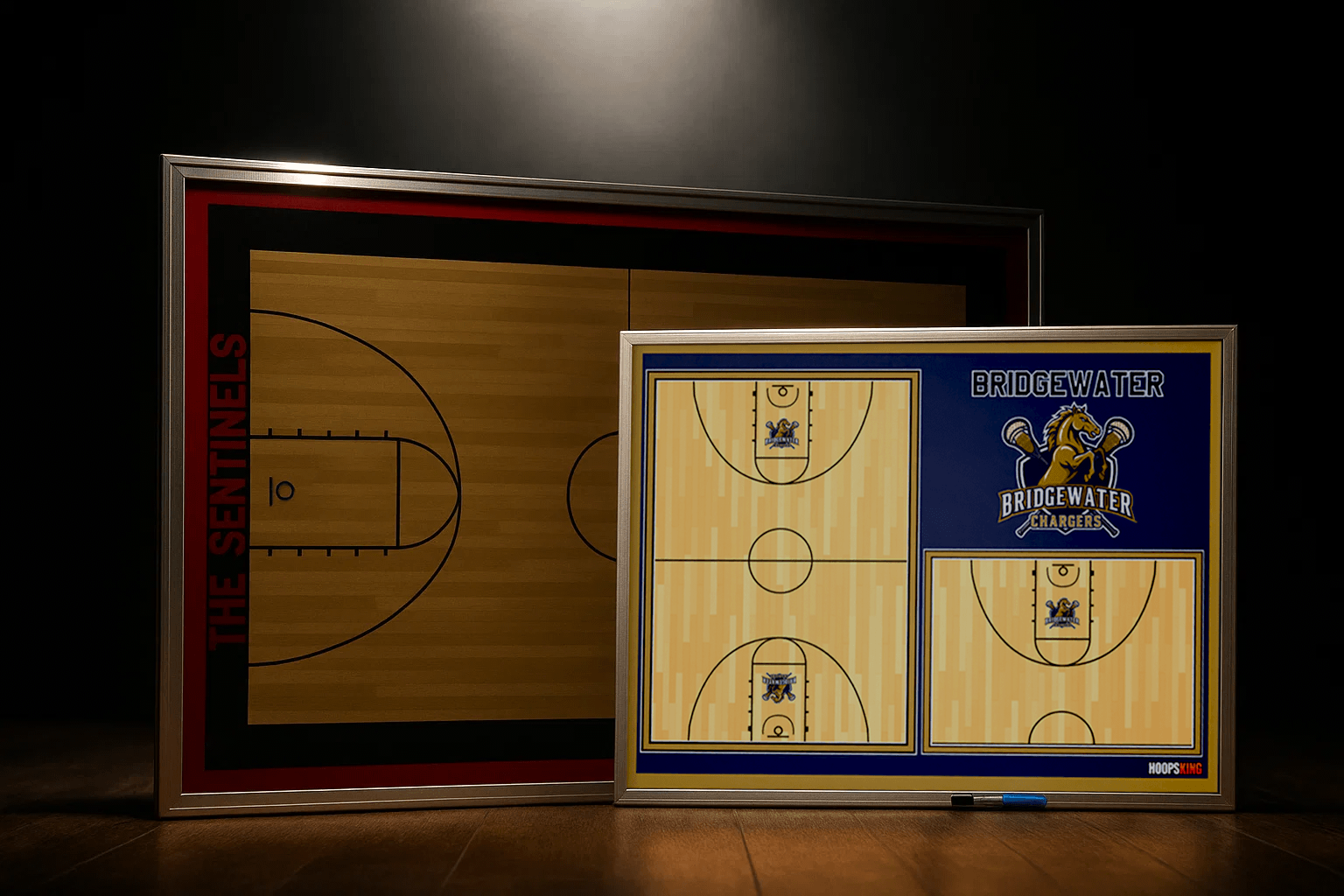 A smiling basketball coach points to a play on a large, wall-mounted