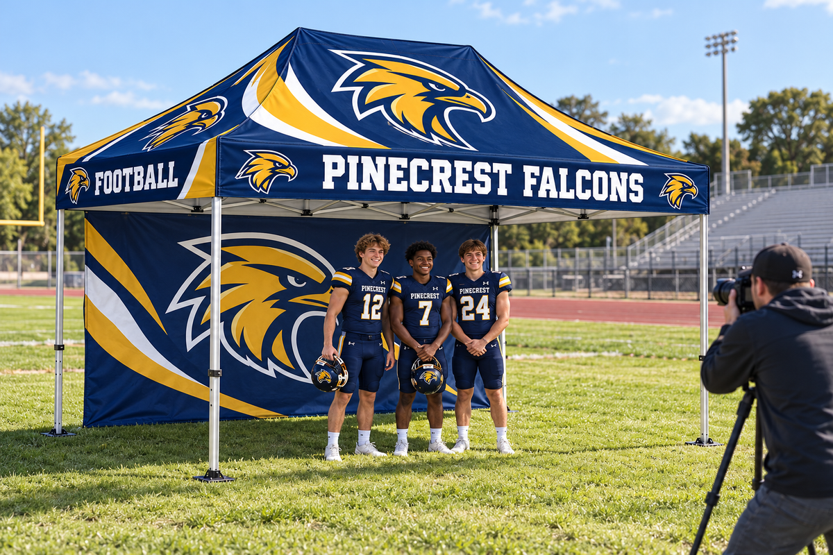 School athletes pose for a photographer in front of a custom printed tent wall.