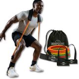 Man using resistance bands attached to shoulders and ankles, with a bag of bands and straps beside him.