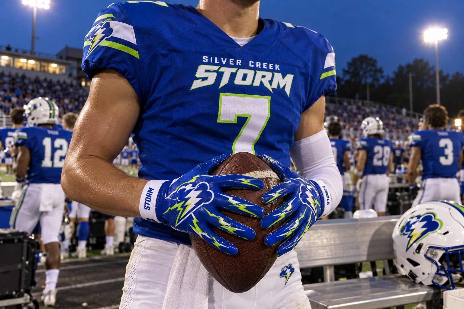 Storm player holding a football in royal blue and lime custom gloves.
