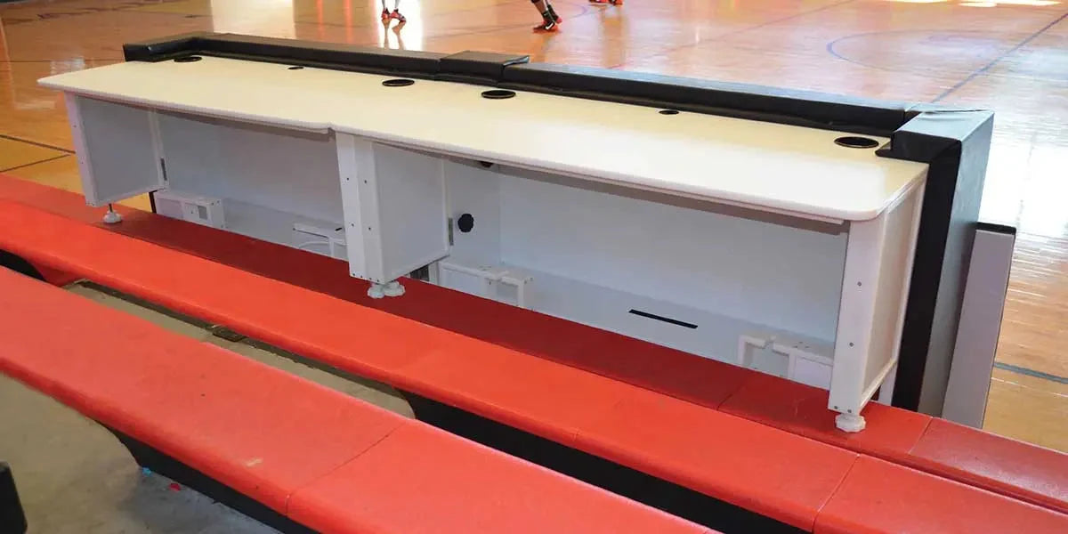 Actual rear view of a Fisher padded scorers table showing white worktop, cable openings, shelving and metal frame