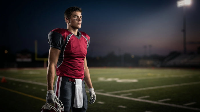 Youth football player in a game-ready stance on the field