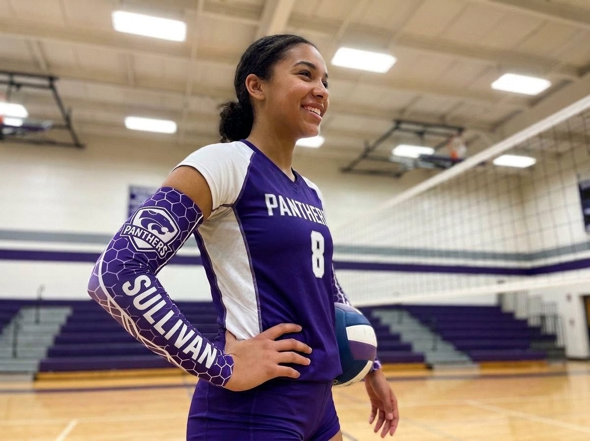 Volleyball player on an indoor court in a jersey and arm sleeve