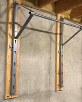 Adjustable chin-up bar mounted on a concrete wall with wooden planks.
