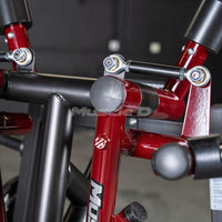 Thumbnail for Close-up of red and black gym equipment frame with connecting rods and bolts.