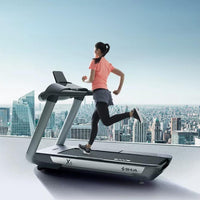 Thumbnail for Woman running on an X6 treadmill with an LED console, overlooking a city skyline.