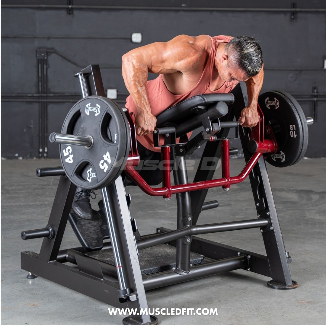 Man performing a chest-supported row exercise on a black and red leverage machine with weight plates.