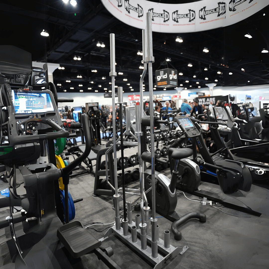 Vertical Olympic bar rack with 5 bars in a gym setting.