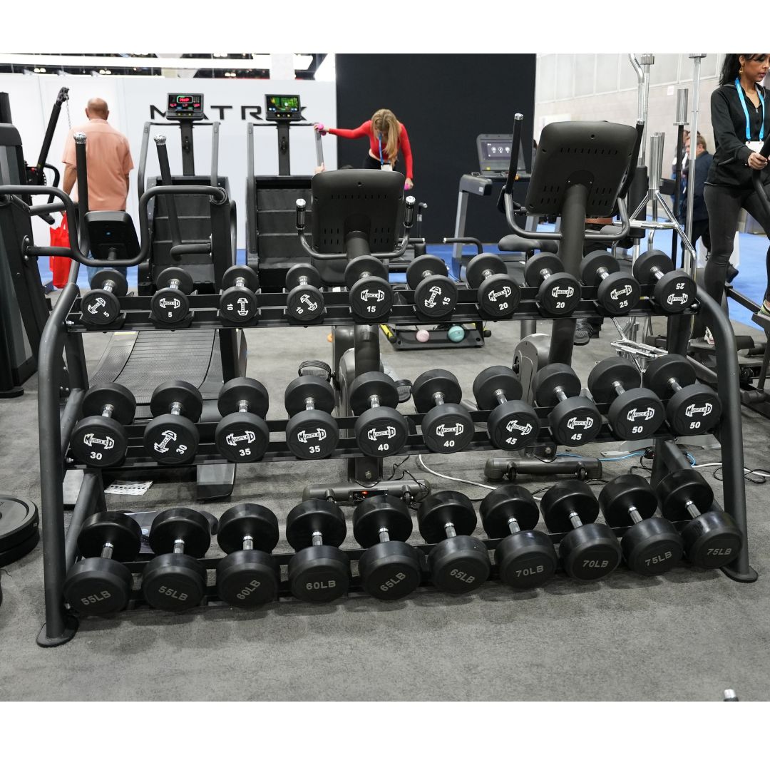 Black 3-tier commercial dumbbell rack with various dumbbells in a gym setting.