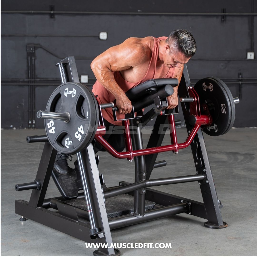 Man performing a chest-supported row exercise on a black and red linear bearing row machine with weights.