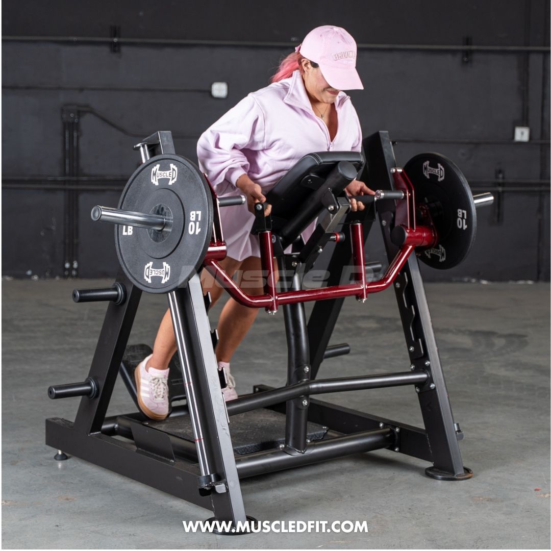 Woman in pink hat and jacket using a chest-supported linear bearing row machine with 10lb plates.