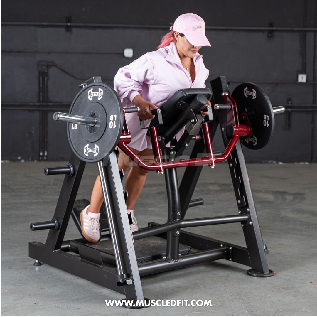 Woman in pink shirt and cap using a chest-supported linear bearing row machine with weight plates.