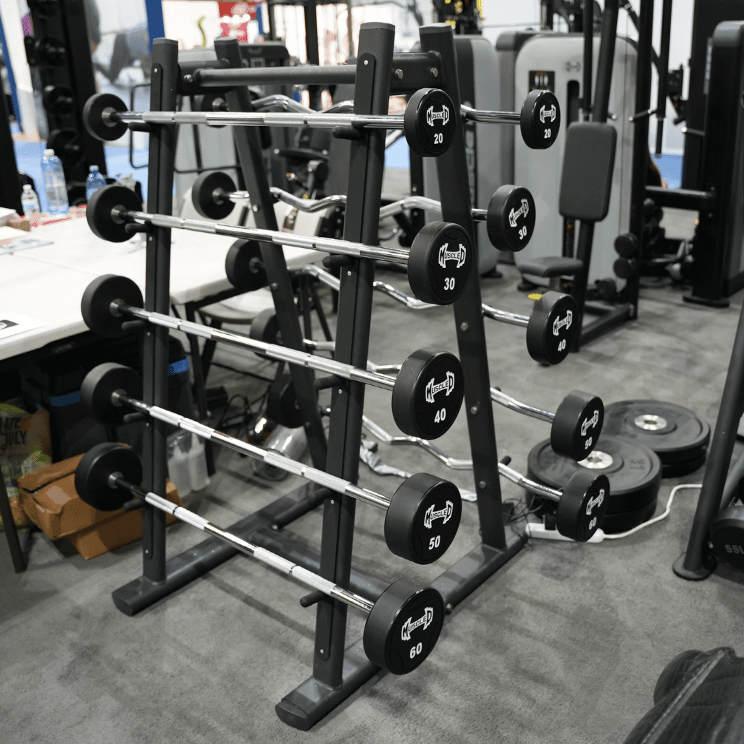 Black urethane barbell set on a rack, ranging from 20 to 60 lbs, in a gym setting.