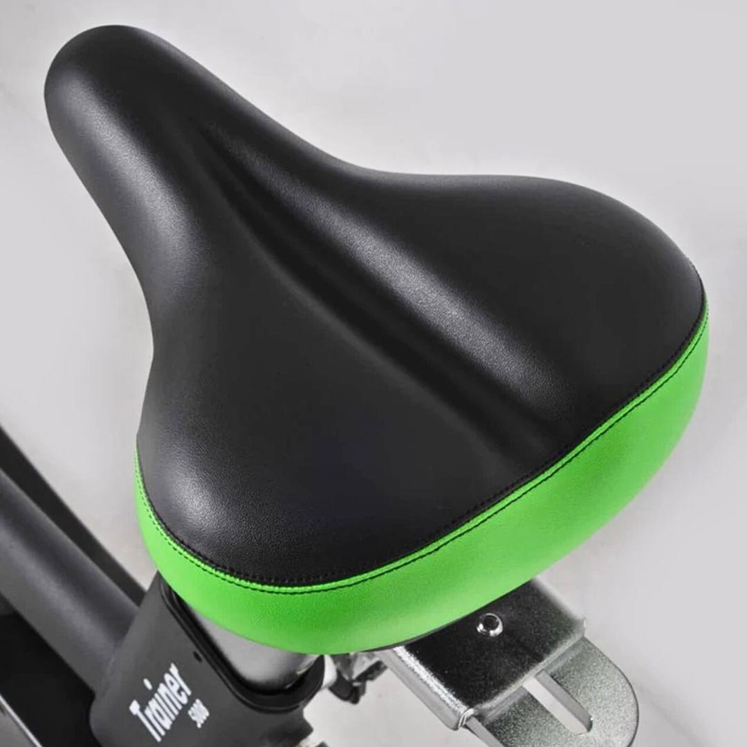 Black and green padded exercise bike seat.