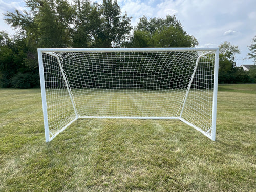 White aluminum soccer goal with net on a grassy field under a cloudy sky.