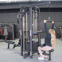 Thumbnail for Woman doing lat pulldowns on a black 4-stack jungle gym in a gym.