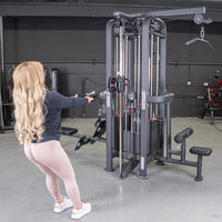 Thumbnail for Woman doing a low row on a 4-stack jungle gym machine with multiple pulleys and weight stacks in a gym.