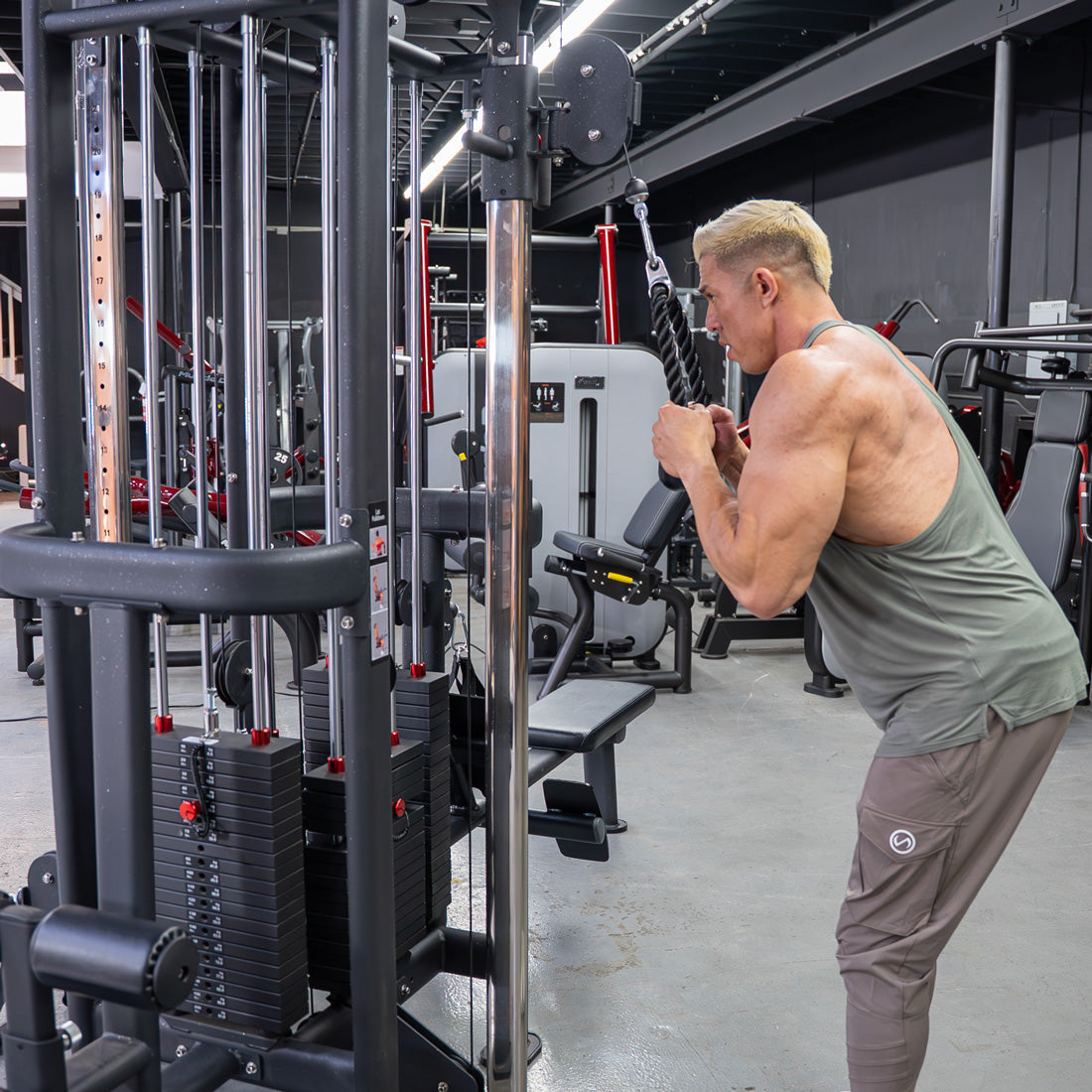 Man using a 4-stack cable jungle gym with weight stacks in a gym.