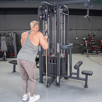 Thumbnail for Man using a 4-stack cable jungle gym with multiple weight stacks and pulleys in a gym setting.