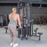 Thumbnail for Man in gray tank top using a 4-stack cable jungle gym with a low row attachment in a gym.