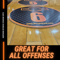 Thumbnail for Two round black and orange HoopsKing training spot markers with numbers 5 and 6 on a wooden court.