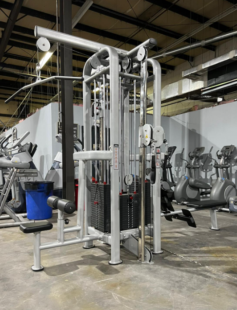 Silver 4-stack jungle gym with multiple pulleys and weight stacks in a gym setting.