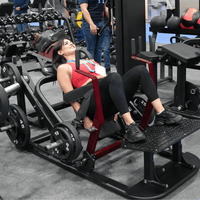 Thumbnail for Woman in red top using a plate-loaded hip thruster machine in a gym, smiling.