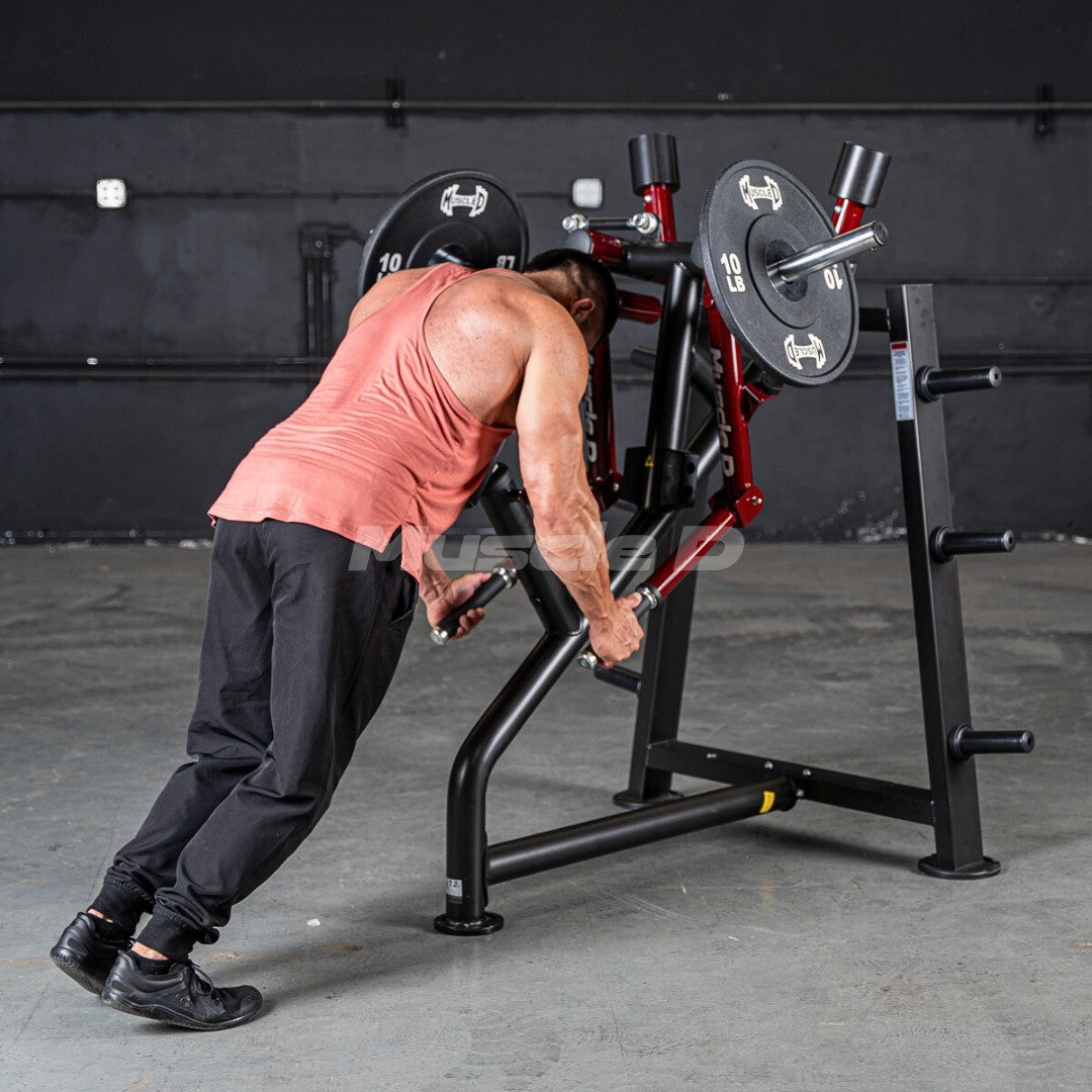 Man in a tank top using a black and red leverage rear delt machine with weight plates.