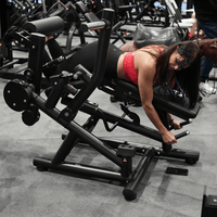 Thumbnail for Woman using a black leg extension/curl machine in a gym.