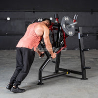 Thumbnail for Man in tank top using a red and black leverage rear delt machine with weight plates in a gym.