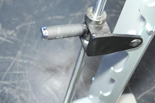 Close-up of a black and silver Smith machine's plate storage peg and safety stop.