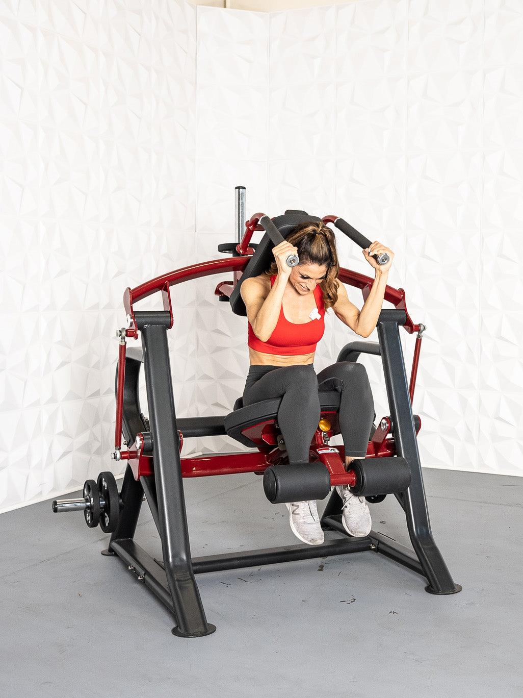 Woman in red top and black leggings using a red and black plate-loaded seated abdominal crunch machine.