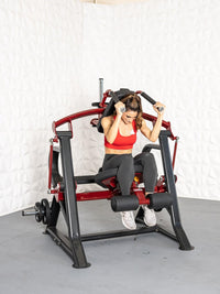 Thumbnail for Woman in red top and black leggings using a red and black plate-loaded seated abdominal crunch machine.
