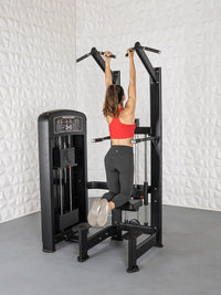 Thumbnail for Woman on a black assisted chin/dip machine, holding handles and kneeling on the pad.