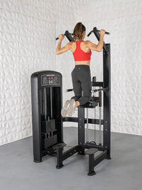Thumbnail for Woman in red top and black leggings using a black assisted chin/dip machine.