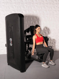 Thumbnail for Woman in red top and black leggings using a black selectorized biceps curl machine.