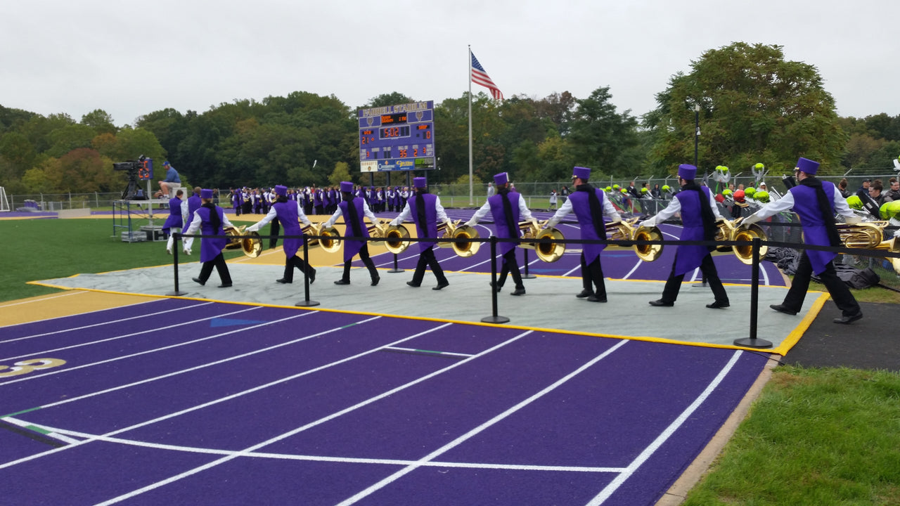 A blanket-style track protector with band members marching across it