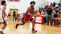 Thumbnail for Basketball player in a red jersey and black arm sleeve dribbling a ball on a court.