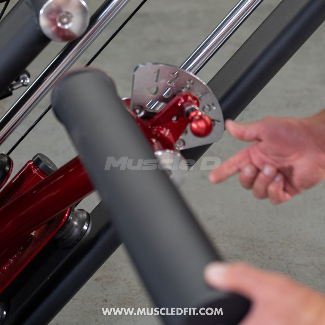 Close-up of a hand adjusting the numbered red pin on a black and red glute kick machine.