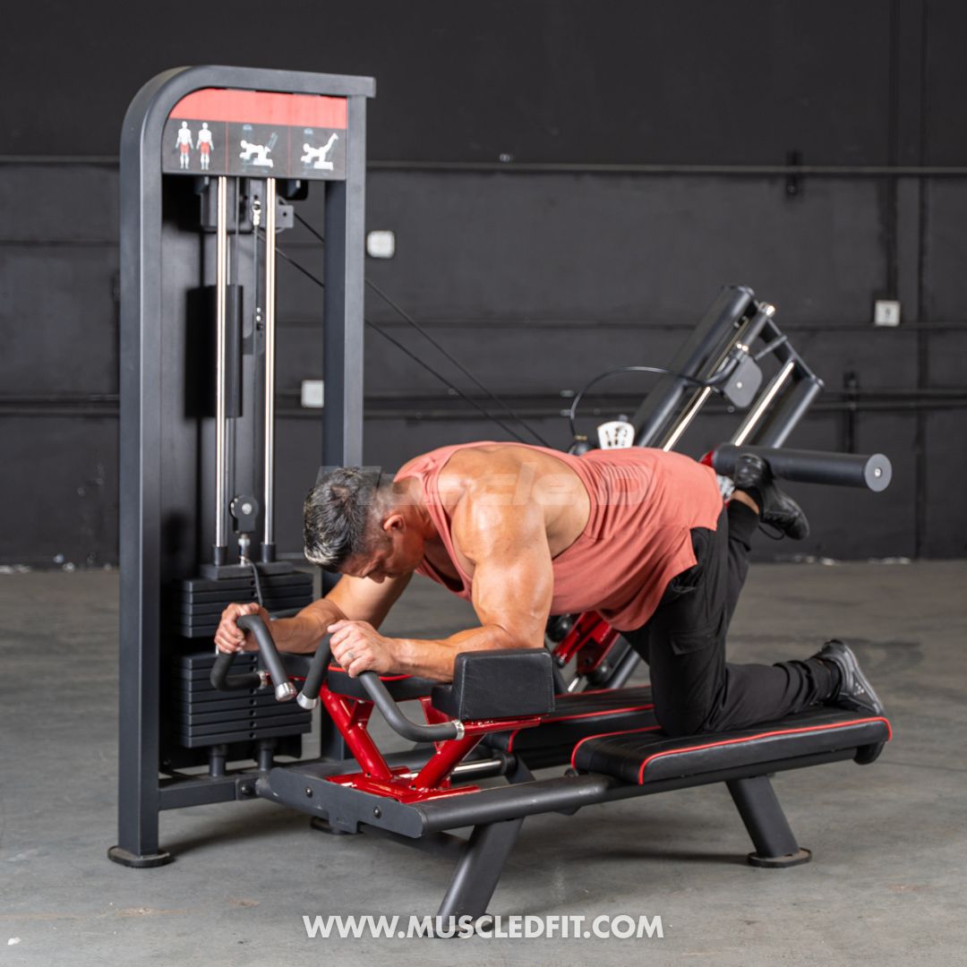 Man using a black and red selectorized glute kick machine in a gym.