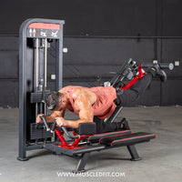 Thumbnail for Man using a red and black selectorized glute kick machine in a gym.