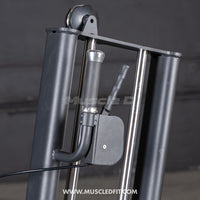 Thumbnail for Close-up of a black selectorized glute kick machine, showing the handle, weight stack pin, and pulley system.