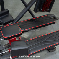 Thumbnail for Close-up of black padded footrests and knee pads with red trim on a glute kick machine.
